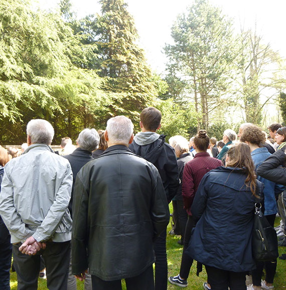 Menschengruppe bei einer Veranstaltung auf dem Friedhof